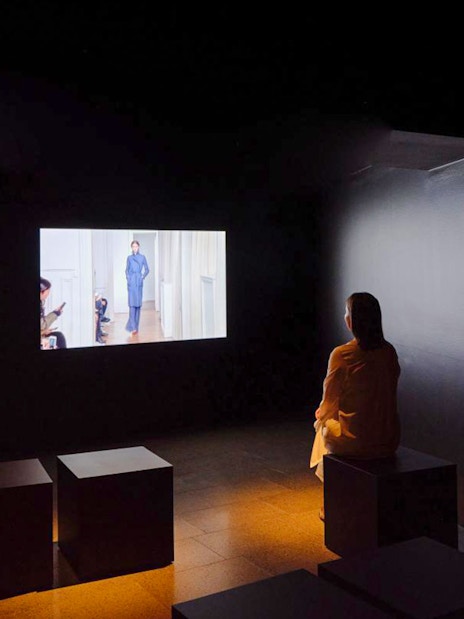 Visitor watching a short film at Martin Grant exhibit.