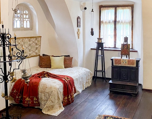 Bran Castle, Romania: Queen Mary's bedroom with ornate bed and vintage decor.