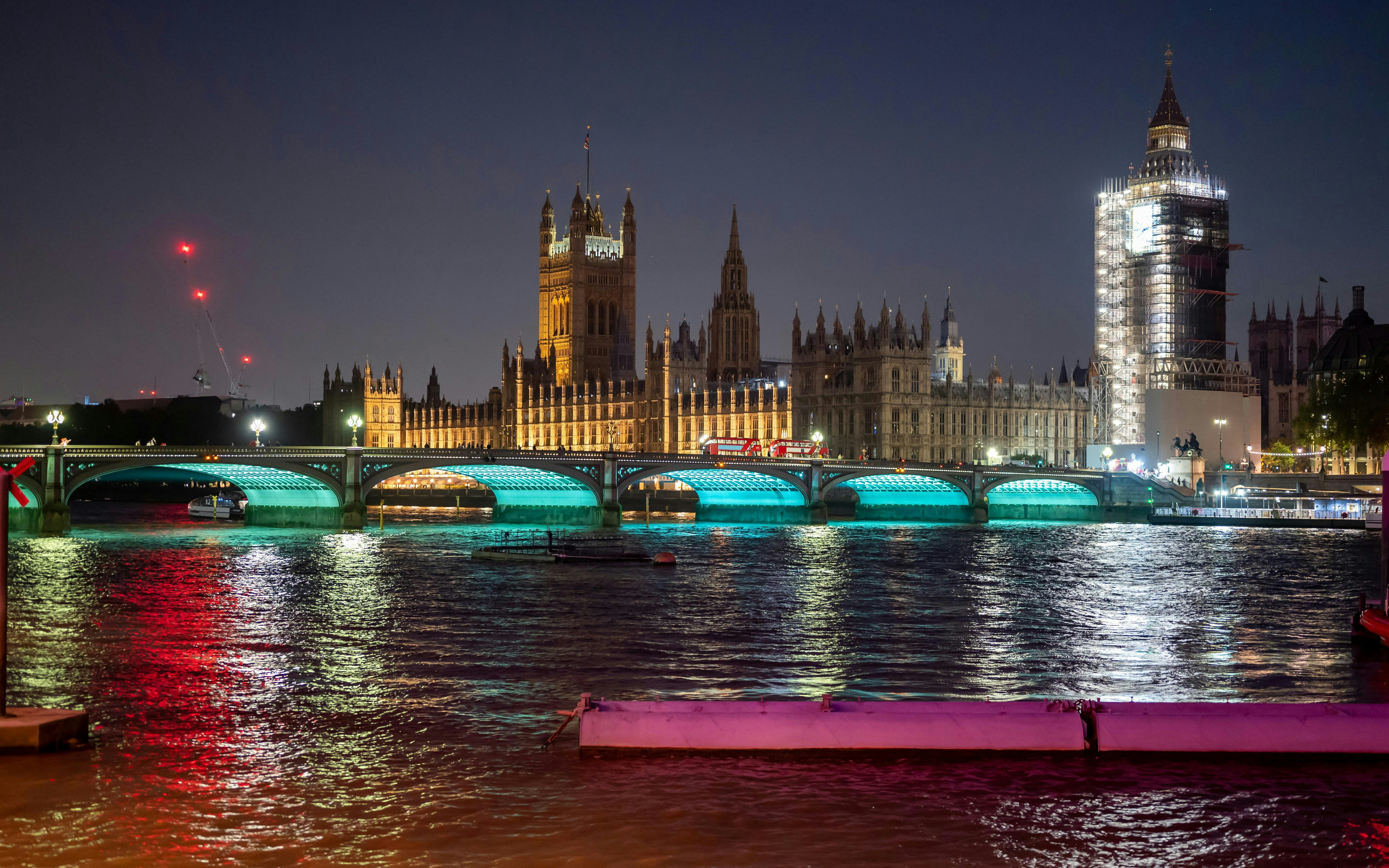 Westminster Bridge and Houses of Parliament illuminated at night, London.