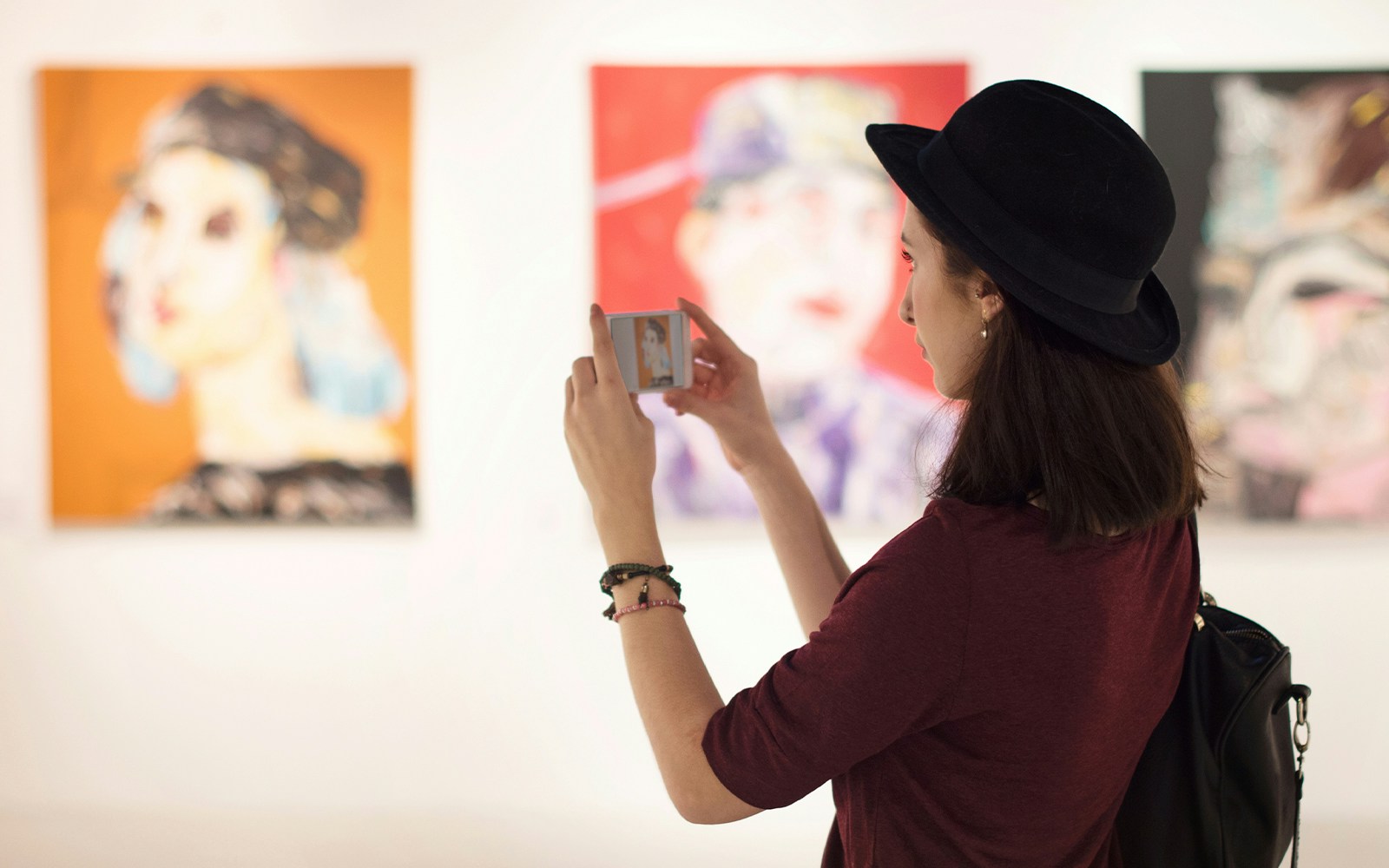 Visitor photographing artwork in an art museum.
