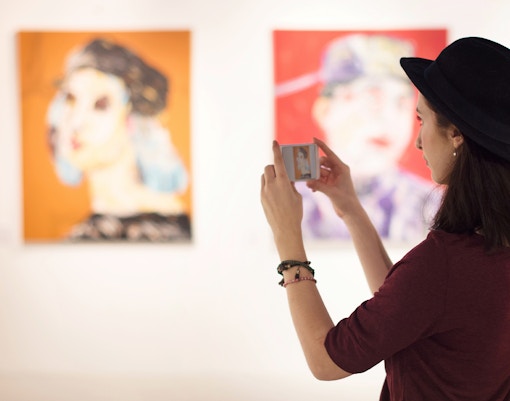 Visitor observing artwork in a gallery at an art museum.
