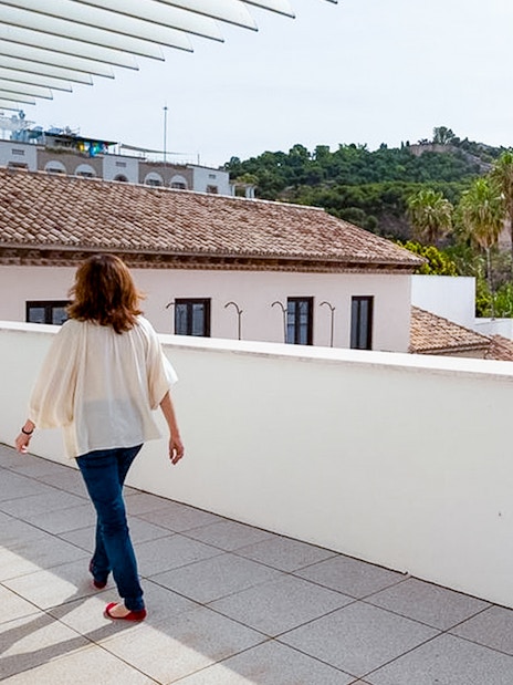 Visitor walking on the terrace of the Picasso Museum in Malaga, with cityscape views.