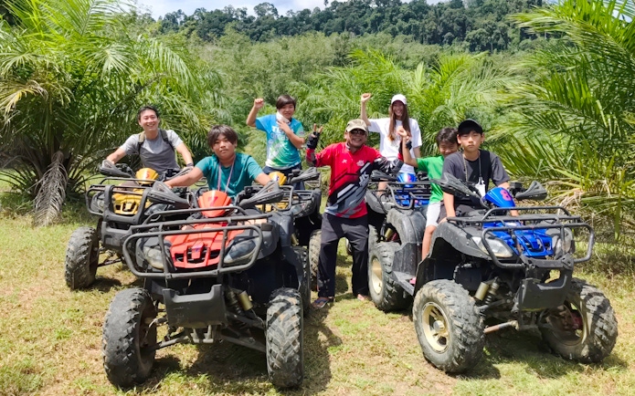 Group enjoying an ATV ride through lush greenery.