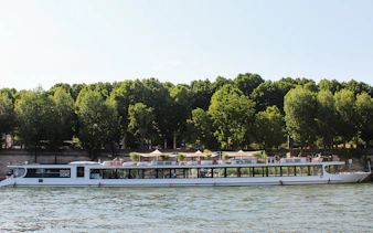 Seine River cruise boat with dining area, Paris.