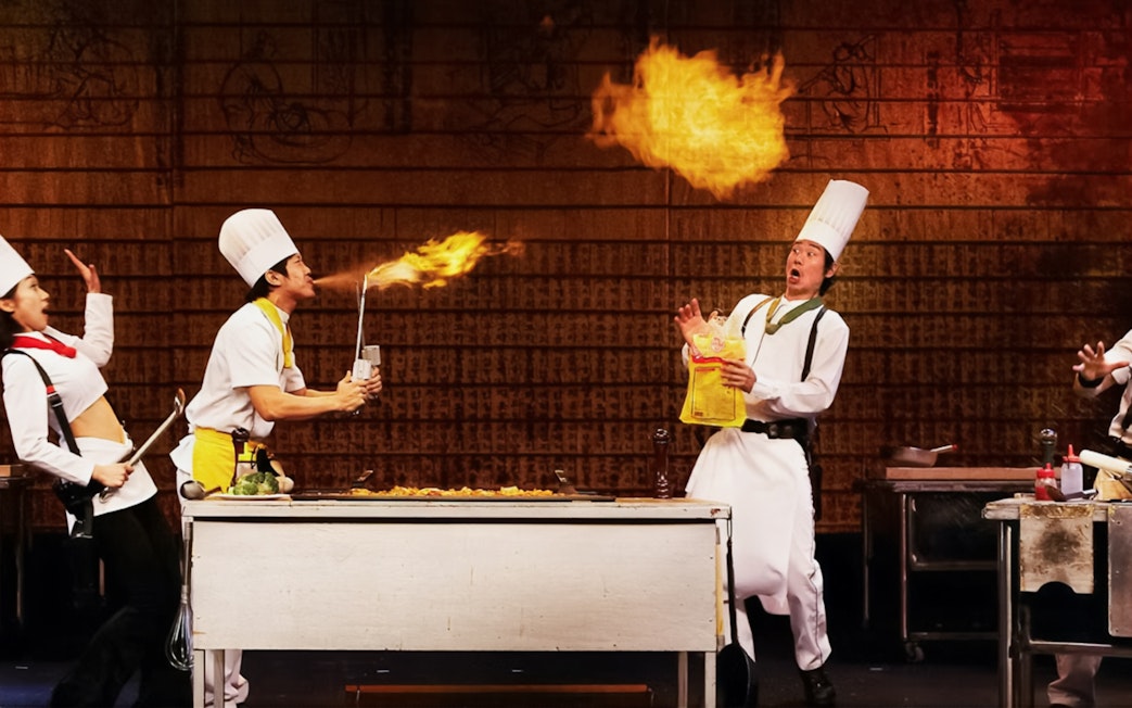 Chefs performing a comedic cooking act with fire during Seoul Night Guided Tour's Nanta show.