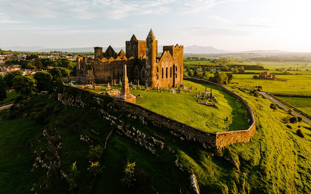 Aerial view of the Rock of Cashel, Ireland, with surrounding green landscape.