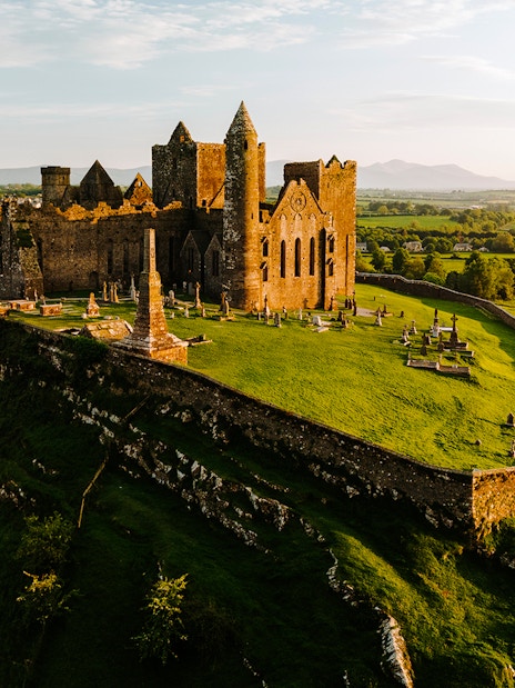Aerial view of the Rock of Cashel, Ireland, with surrounding green landscape.