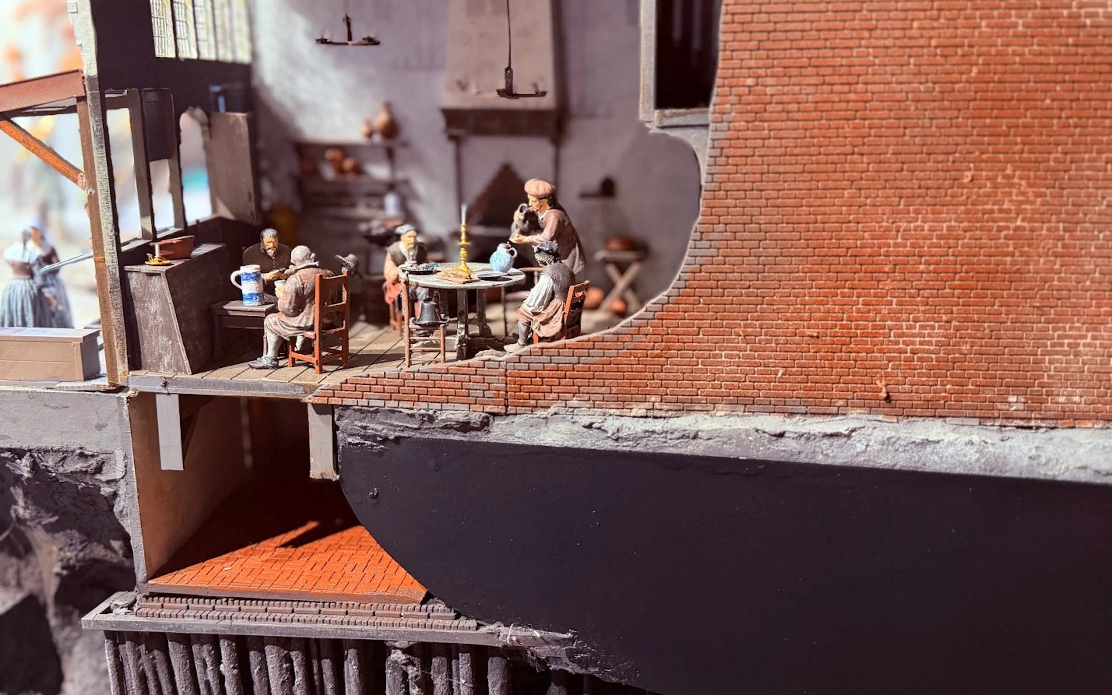 Miniature scene of people dining in a historical building interior.