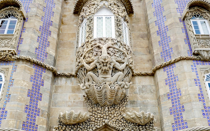 Facade detail of National Palace of Pena with intricate stone sculpture, Sintra, Portugal.