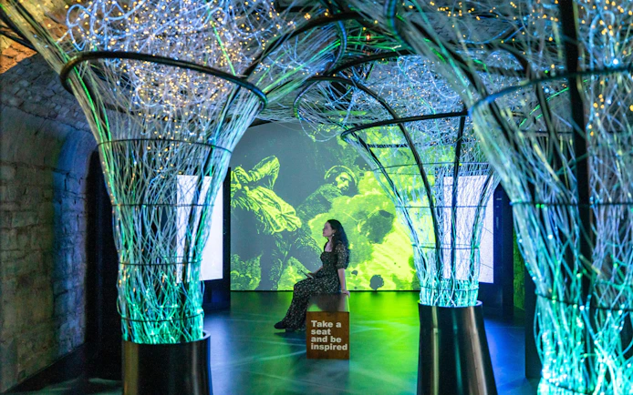 Interactive exhibit with illuminated structures and digital art at epic museum.
