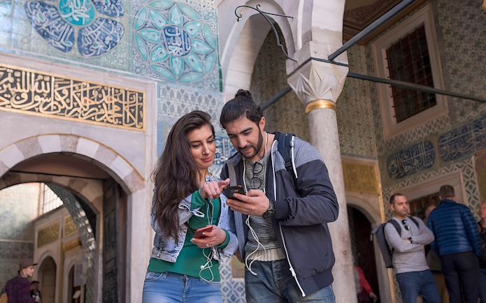 Couple using audio guide inside the Blue Mosque, Istanbul.