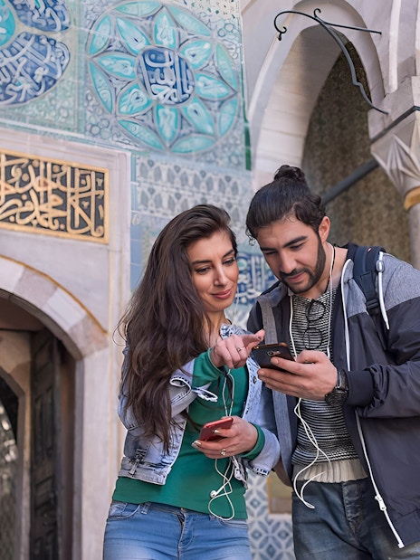 Couple using audio guide inside the Blue Mosque, Istanbul.