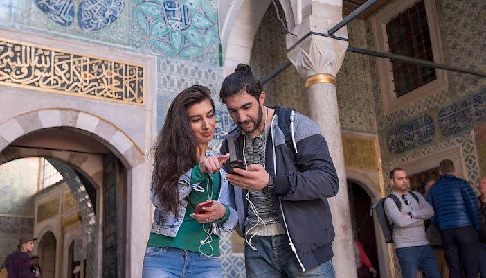 Couple using audio guide inside Istanbul's Blue Mosque.