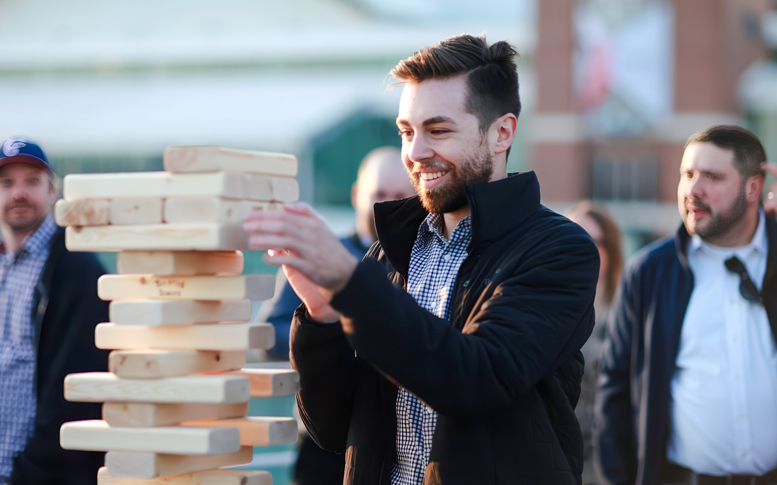 Man playing Jenga on Chicago River cruise deck.