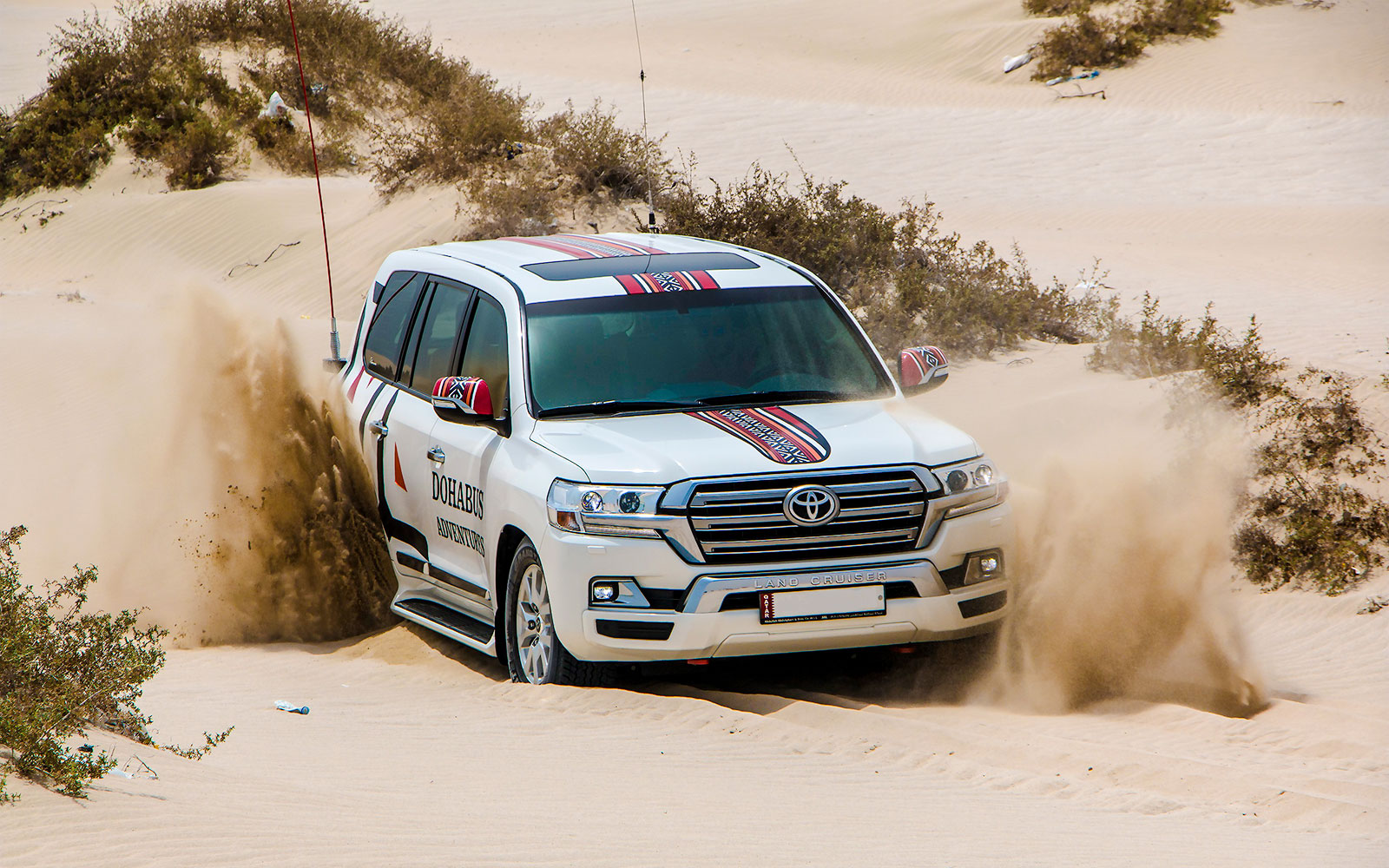 SUV driving through desert sand dunes on a Half Day Desert Safari.