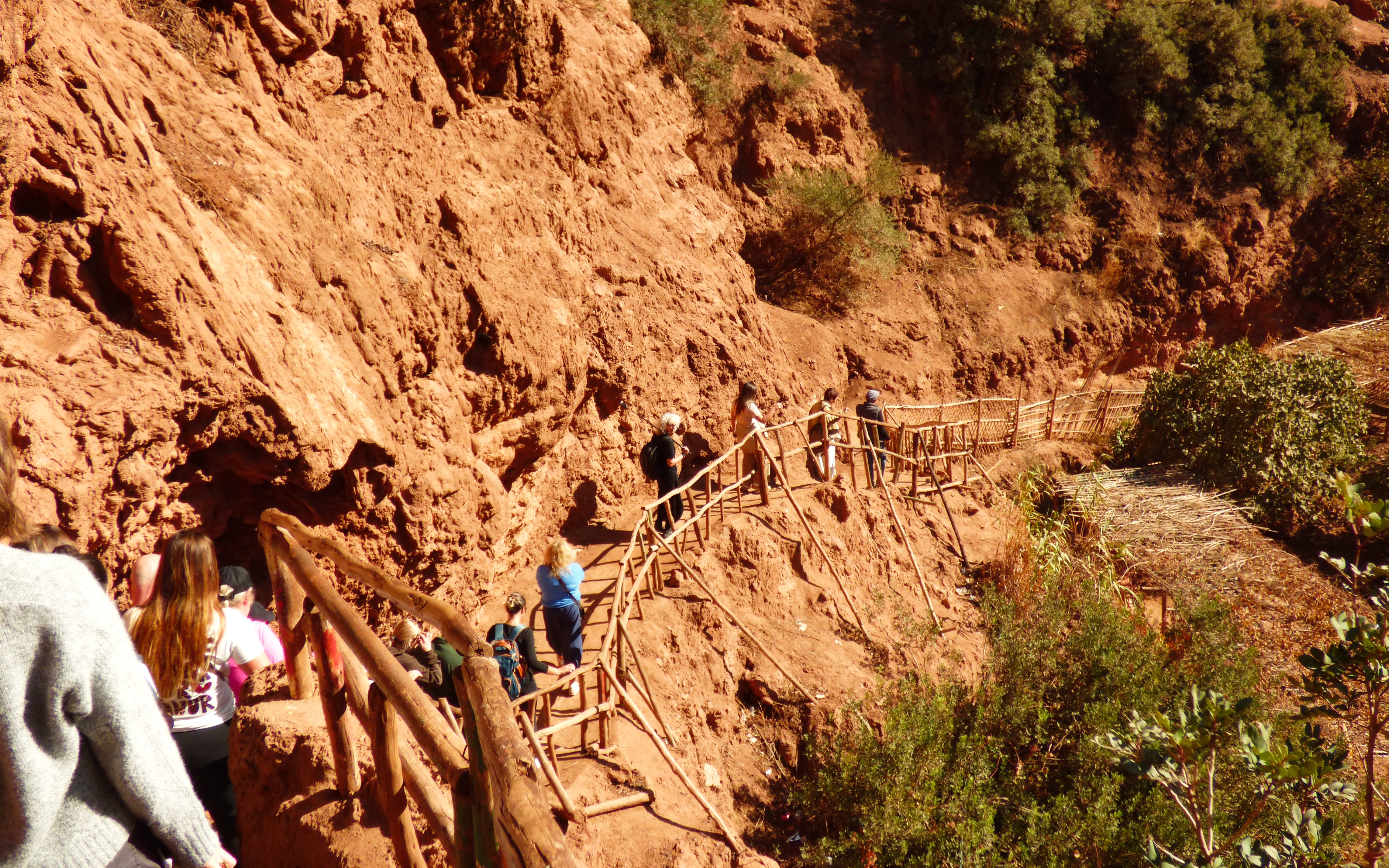 Tourists hiking along a rocky path at Ouzoud Waterfalls, Morocco.
