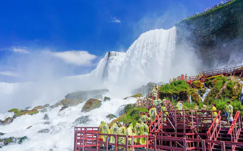 Visitors in raincoats on red walkways at Cave of the Winds, Niagara Falls.