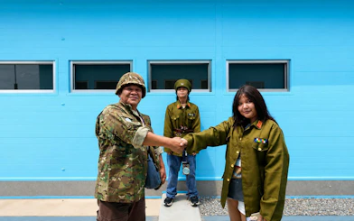 People in military attire shaking hands at the DMZ JSA Photo Zone, South Korea.