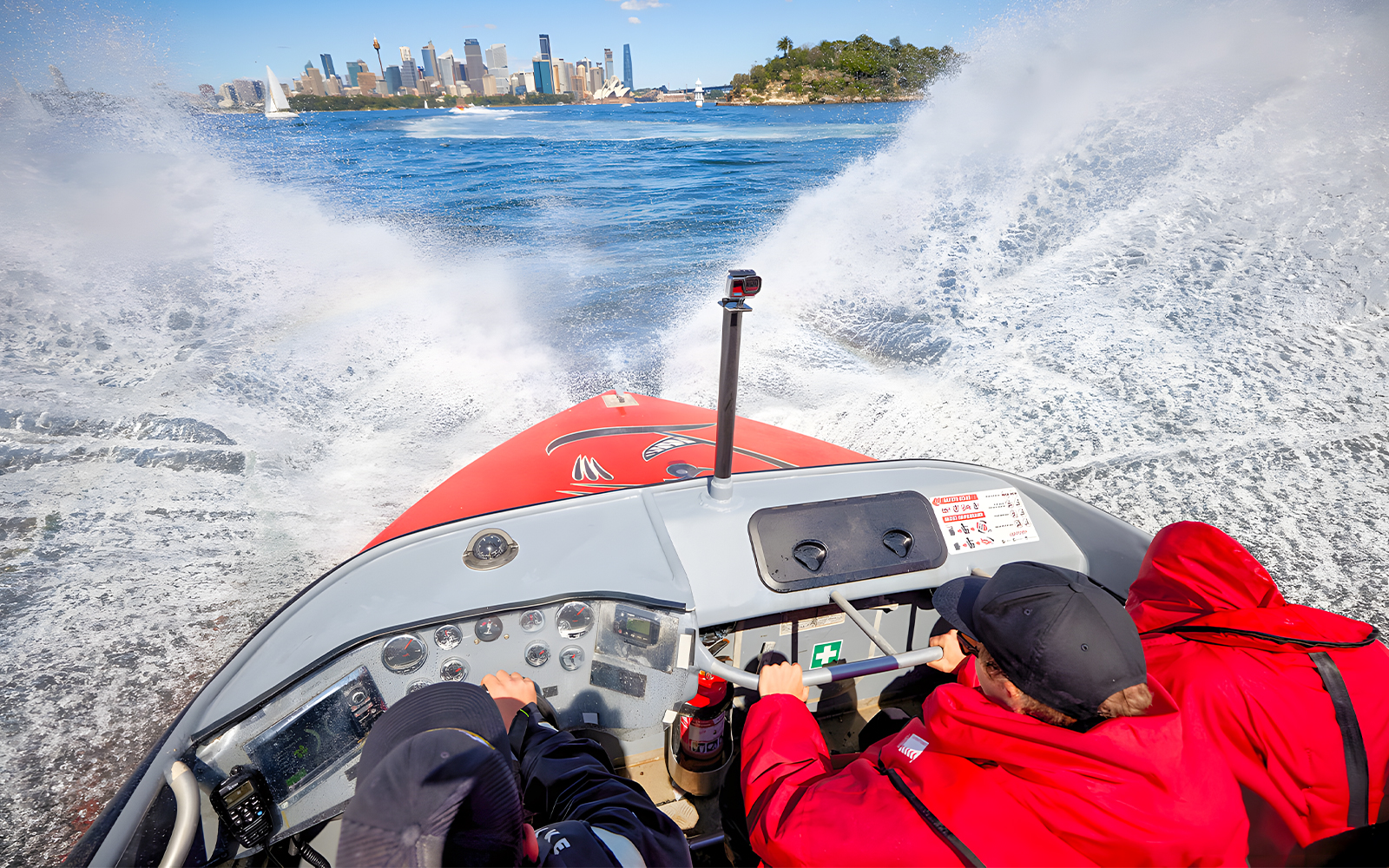 People enjoying OZ Jet Boating in Sydney with city skyline in the background.