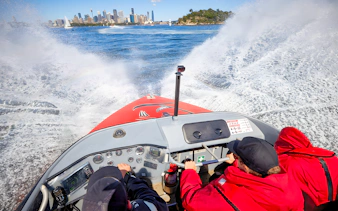 People enjoying OZ Jet Boating in Sydney with city skyline in the background.