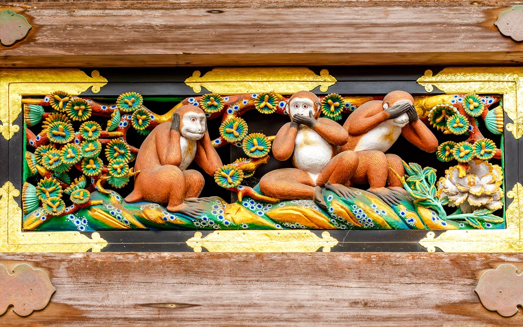 Three wise monkeys carving at Nikko temple, Japan, depicting see no evil, hear no evil, speak no evil.
