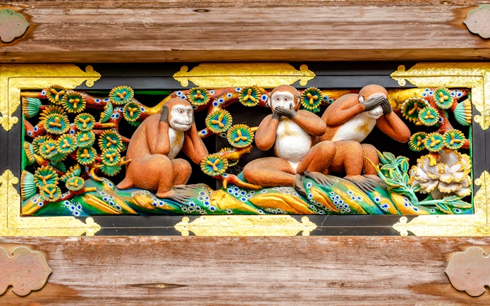 Three wise monkeys carving at Nikko temple, Japan, depicting see no evil, hear no evil, speak no evil.