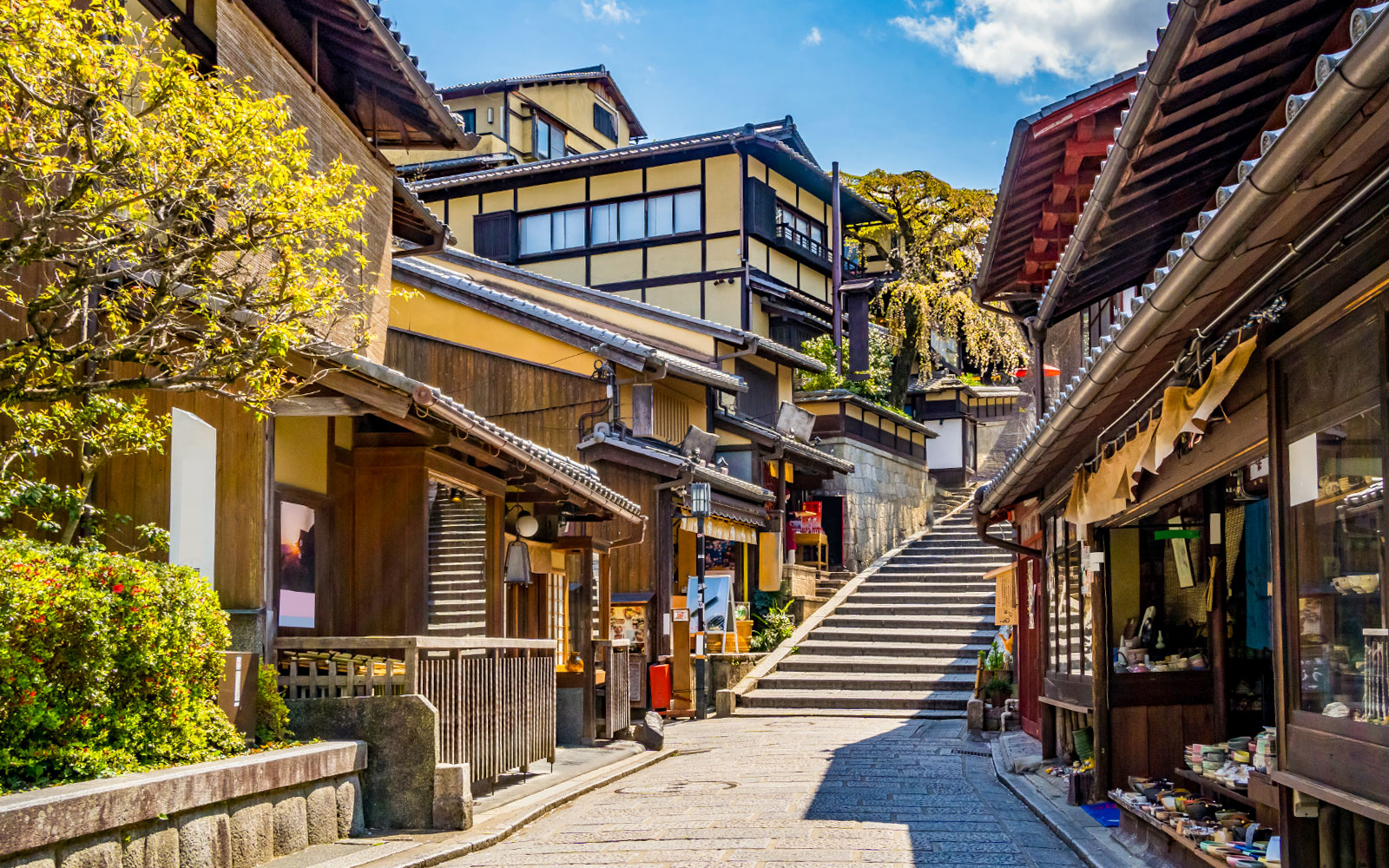 Traditional street in Kyoto near Kiyomizu Temple with wooden buildings and stone steps.