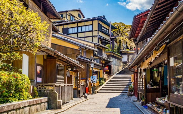 Traditional street in Kyoto near Kiyomizu Temple with wooden buildings and stone steps.
