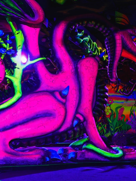 Colorful dragon sculpture in neon lights at National Wax Museum.