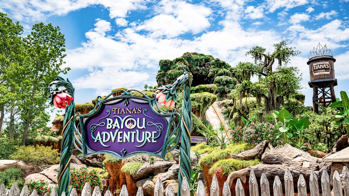 Tiana's Bayou Adventure entrance sign with lush greenery at Walt Disney World Resort, Orlando.