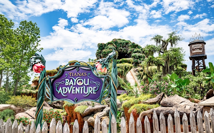 Tiana's Bayou Adventure entrance sign with lush greenery at Walt Disney World Resort, Orlando.