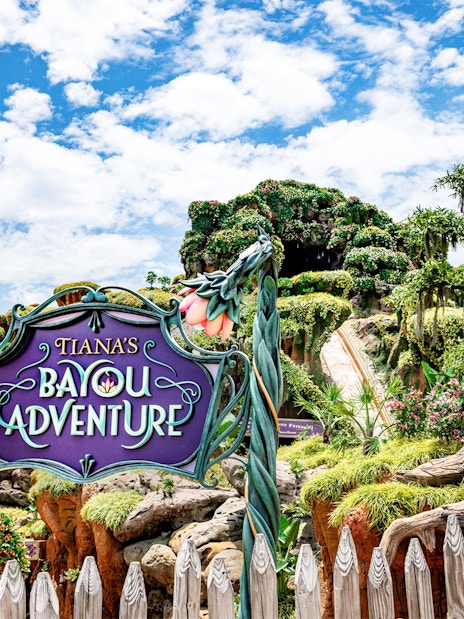 Tiana's Bayou Adventure entrance sign with lush greenery at Walt Disney World Resort, Orlando.