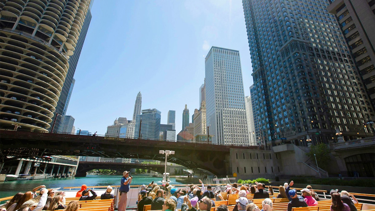 Visitors on Chicago River architecture cruise viewing skyscrapers.