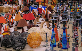 Colorful handicrafts and lamps at a Nairobi market during city excursion.