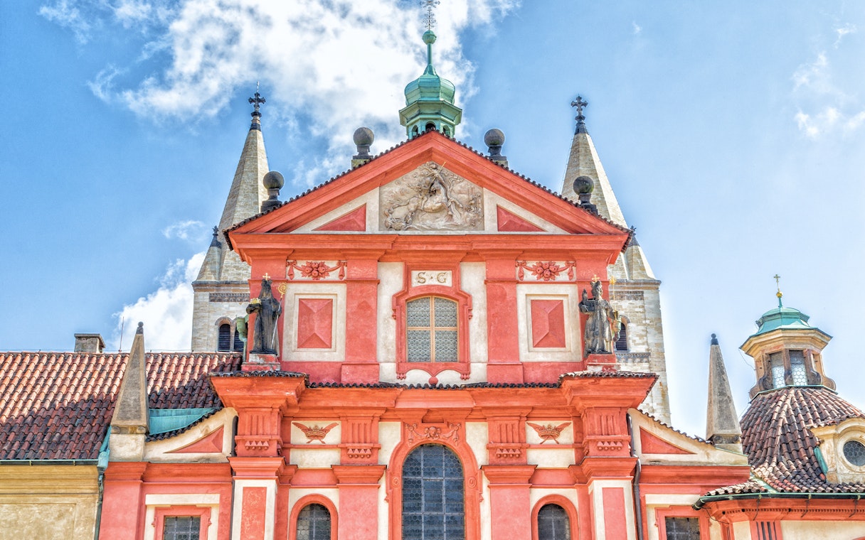 Red facade of St. George Basilica with statues, Prague.