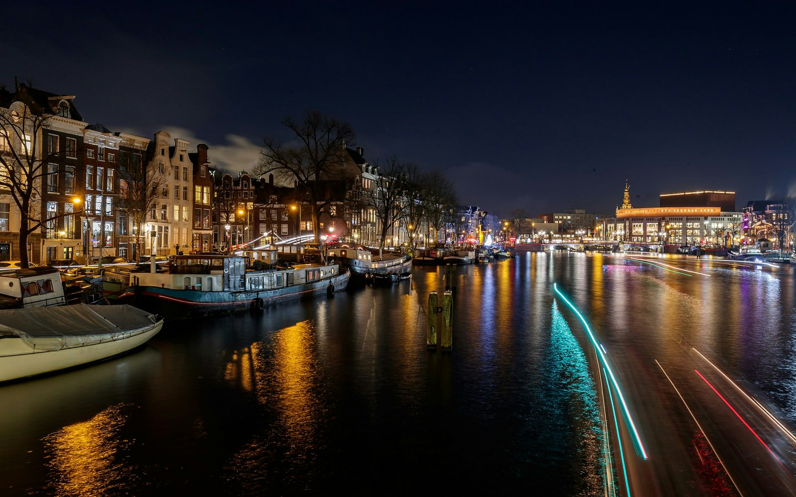 Evening Amsterdam Canal Cruise with Lovers, showcasing a serene view of the city's illuminated architecture reflected in the calm waters