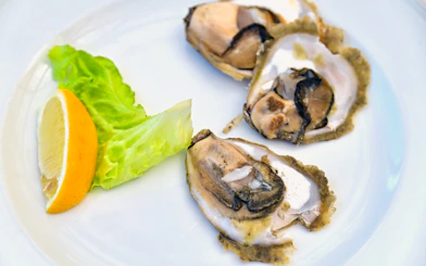 Mali Ston oysters with lemon and lettuce on a plate, Dalmatian dish in Croatia.