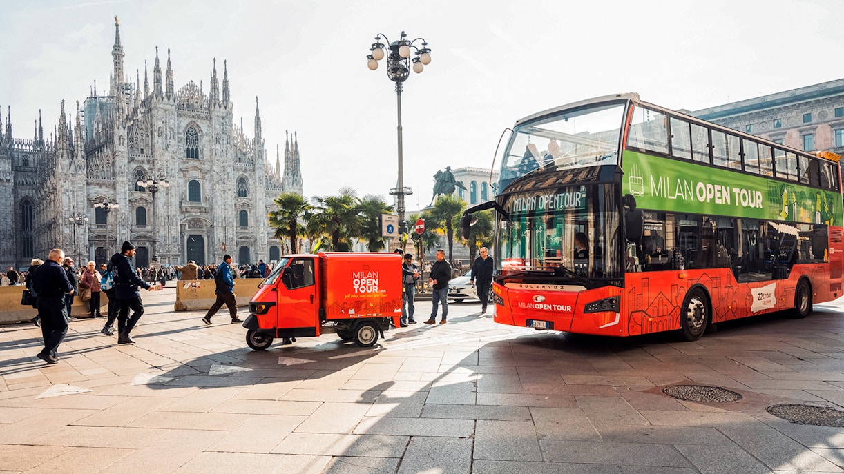 Milan Hop-on Hop-off bus near the Duomo of Milan with tourists exploring the city.