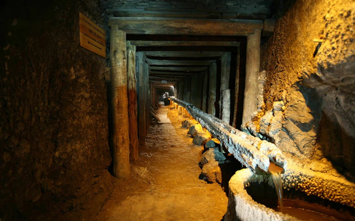 Wieliczka Salt Mine tunnel with wooden supports and brine flow, Krakow tour.