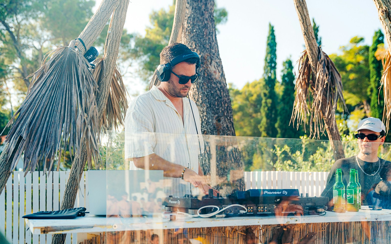 DJ performing at Sunset Boat Party in Split with palm trees in the background.