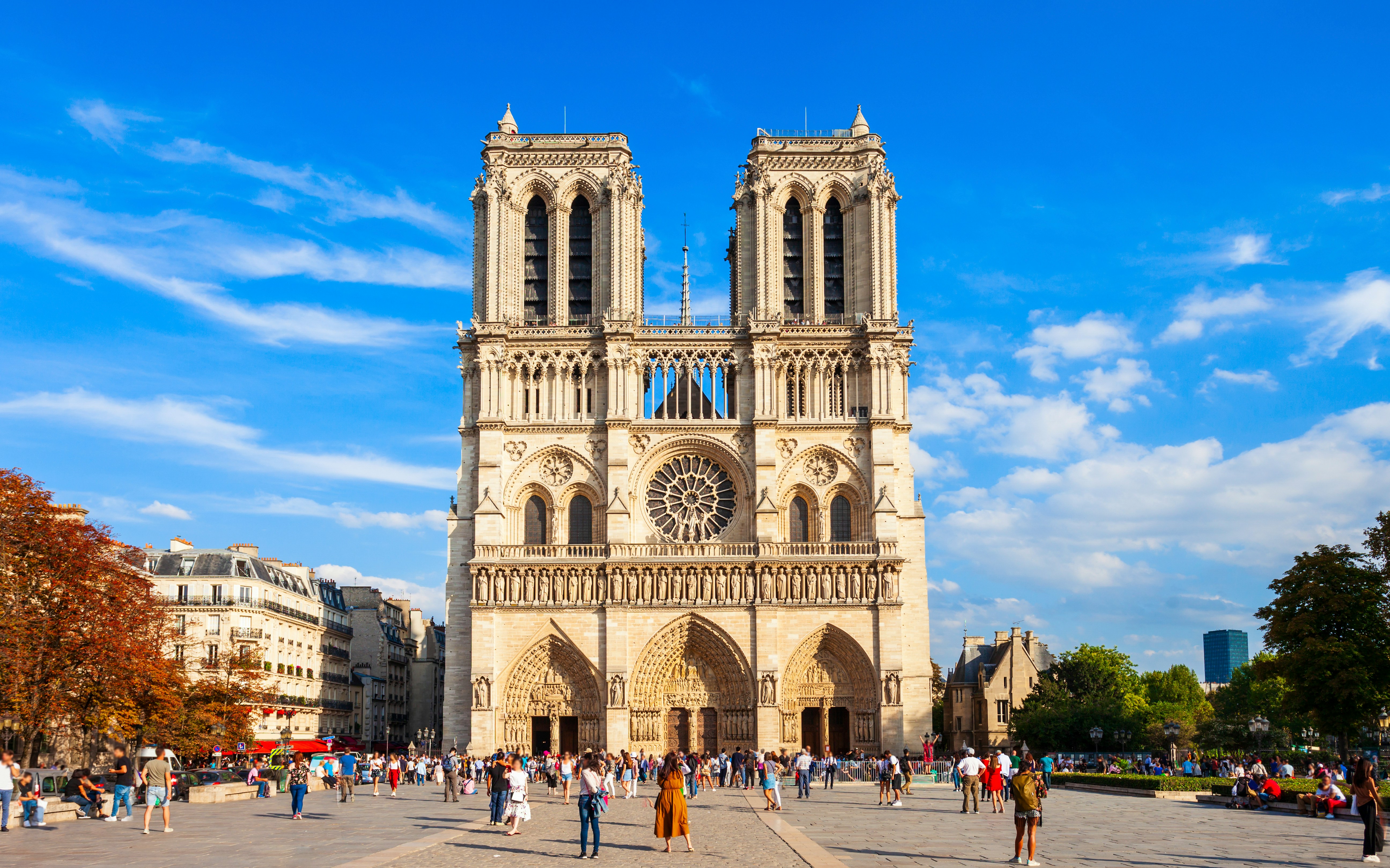 Notre Dame Cathedral facade with visitors in Paris, France.