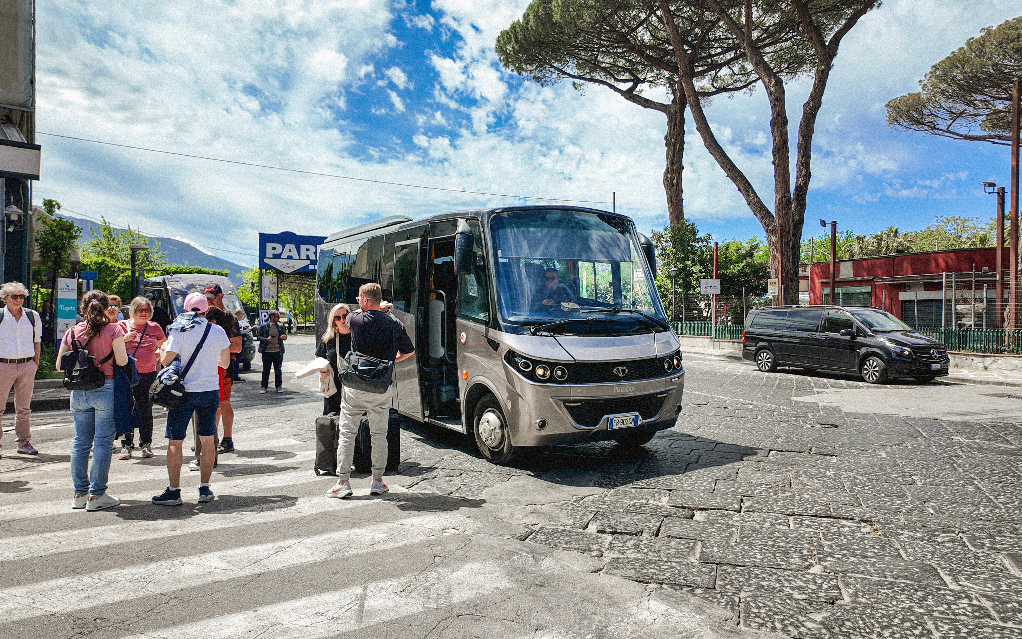 Transfer bus at Mount Vesuvius with tourists boarding.