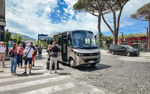 Transfer bus at Mount Vesuvius with tourists boarding.