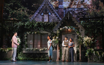 Broadway cast performing The Great Gatsby musical in front of a cottage set.