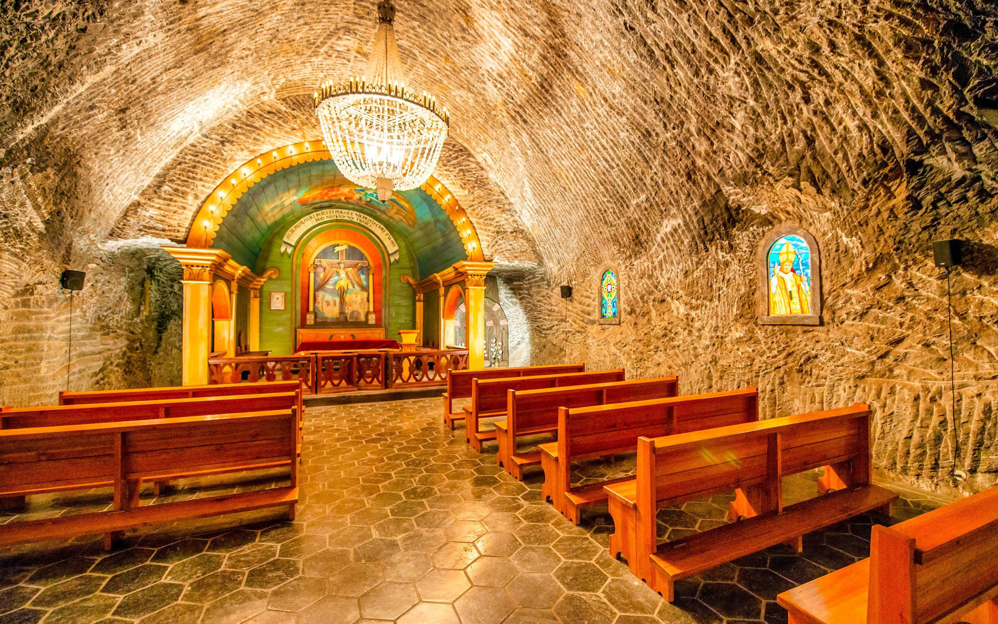 Chapel inside Wieliczka Salt Mine with wooden benches and ornate altar, Krakow, Poland.
