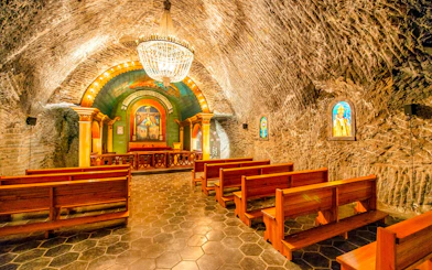 Chapel inside Wieliczka Salt Mine with wooden benches and ornate altar, Krakow, Poland.