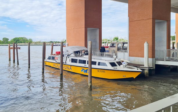 Alilaguna water bus docked at a pier in Venice, Italy.