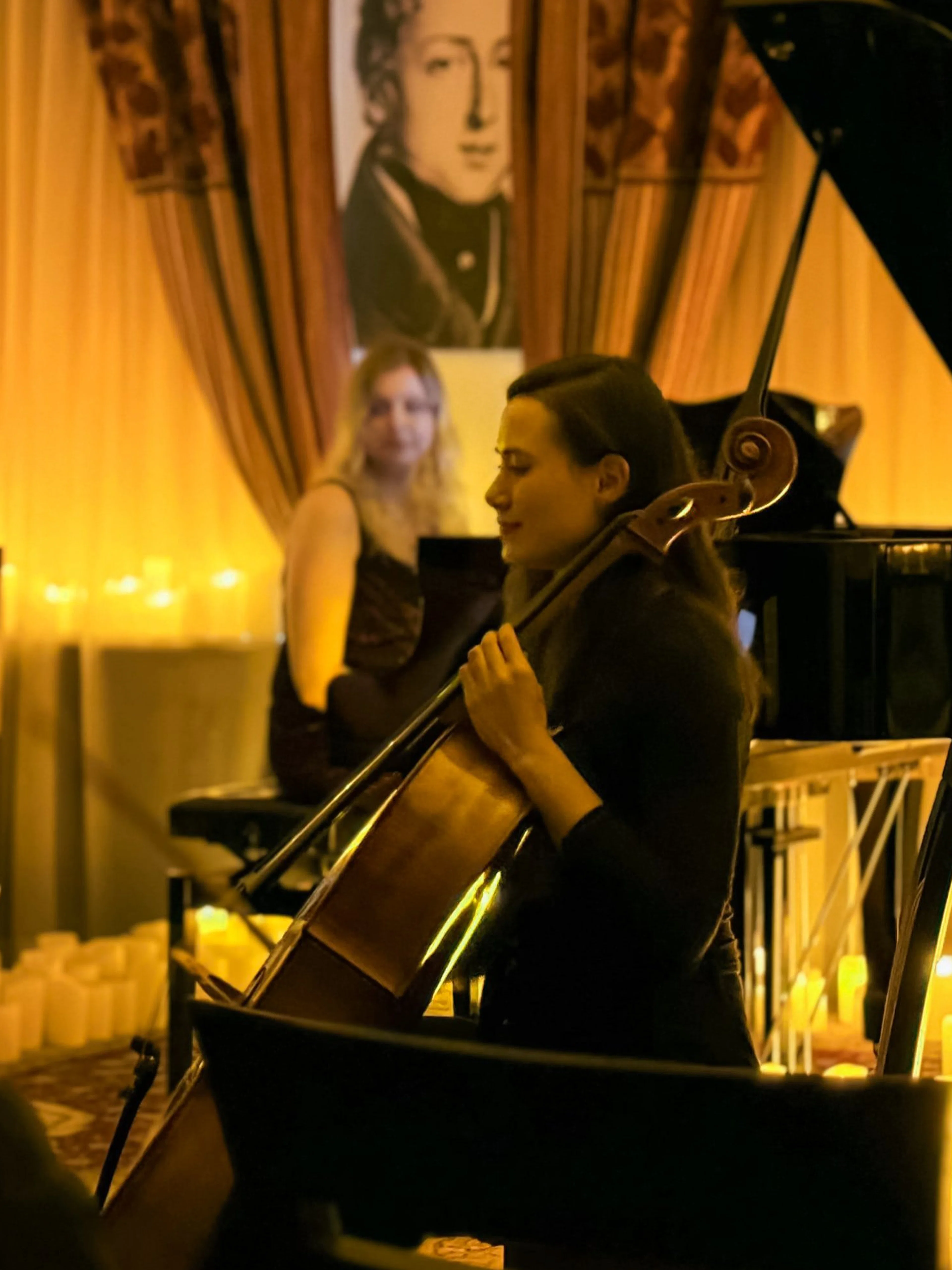 Cellist performing at candlelit Queen music concert, Chopin Gallery, Krakow.