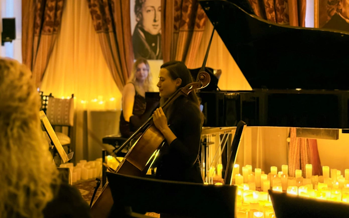 Cellist performing at candlelit Queen music concert, Chopin Gallery, Krakow.