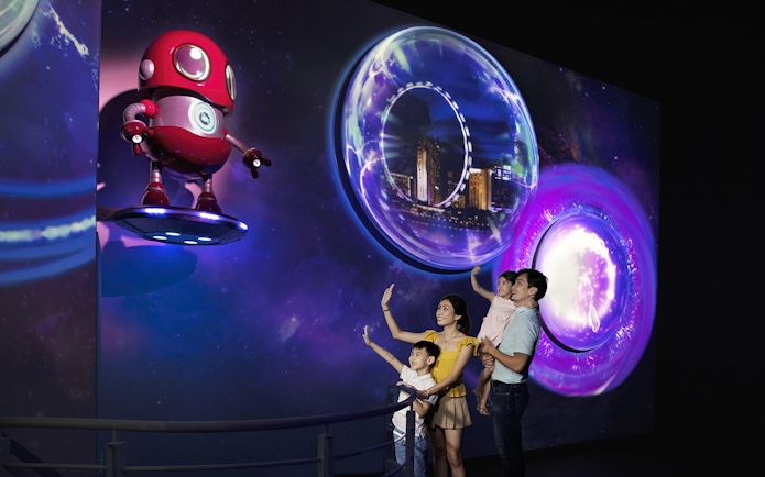 Family exploring interactive display inside the Time Capsule, Singapore.